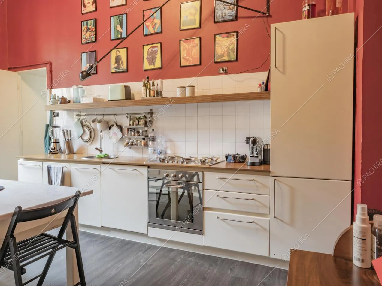 Utensili da cucina appesi su piastrelle bianche e quadretti colorati