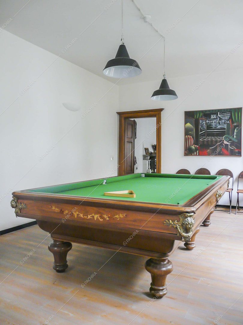 Sala biliardo dalle pareti bianche con pavimento in parquet