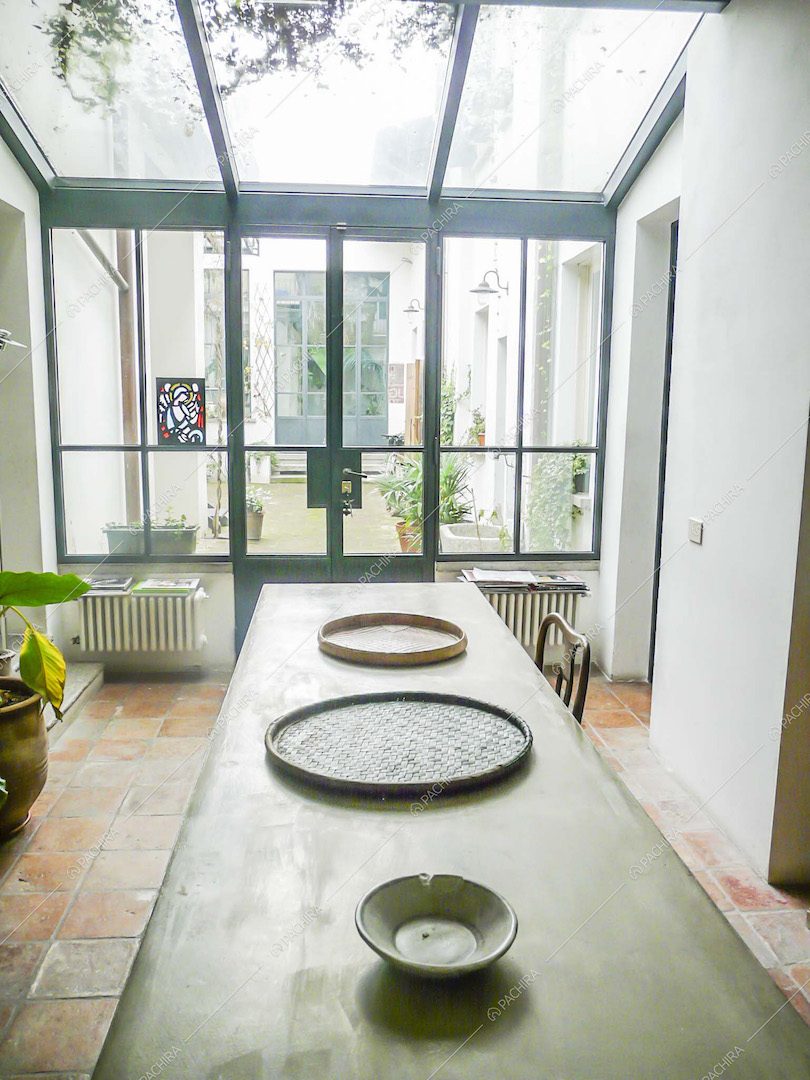 Tavolo in cemento nello studio con soffitto e pareti in vetro in stile industriale