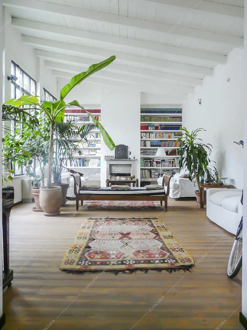 Soggiorno con pavimento in parquet, soffitto con travi in legno a vista e camino