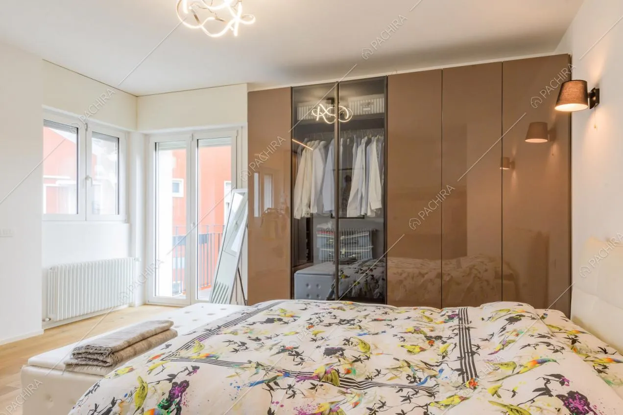 Letto matrimoniale nella luminosa camera con porta-finestra e grande armadio