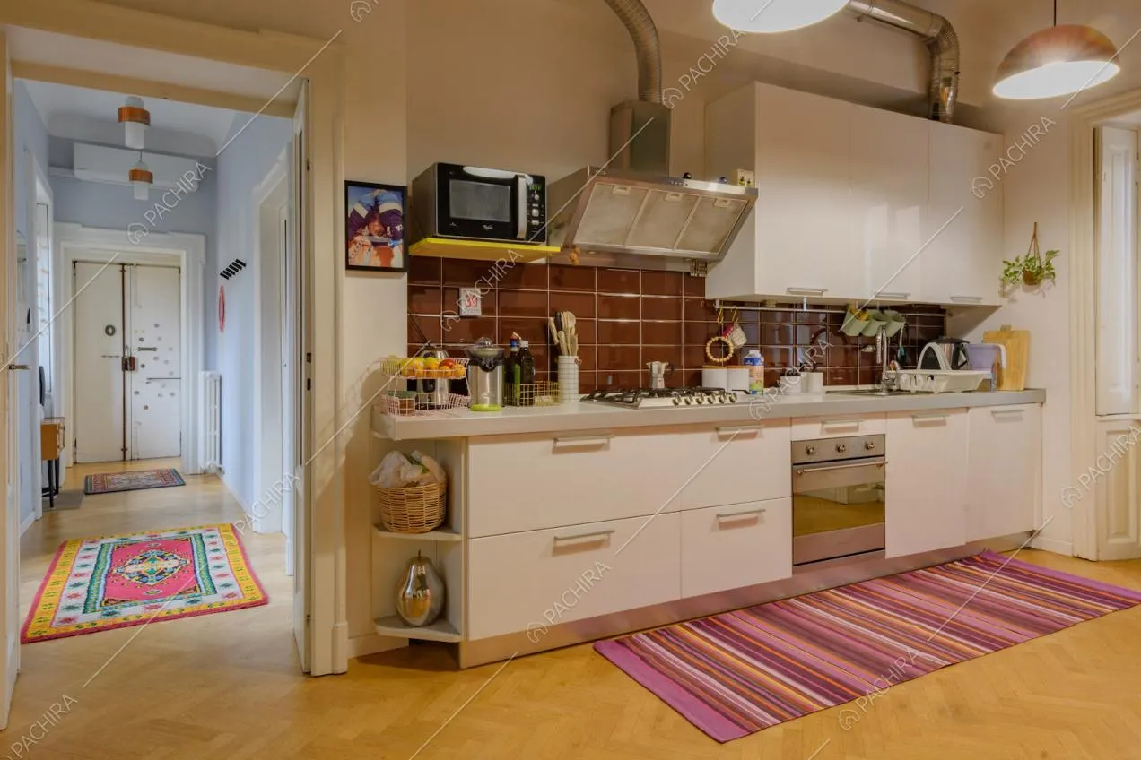 Cucina a parete con paraschizzi in piastrelle marroni e pavimento in parquet a spina di pesce