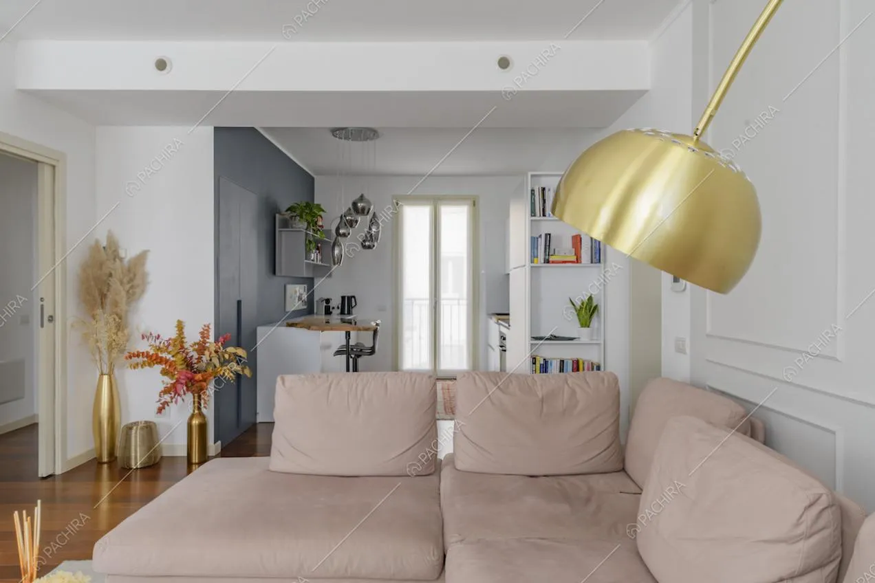 Luminoso salotto con cucina a vista e pareti bianche