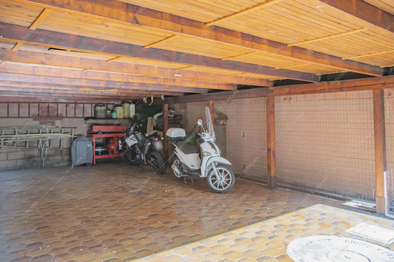 Grande garage con pavimento in cementine e soffitto in travi a vista