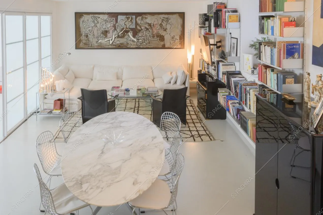 Soggiorno con tavolo ovale in marmo e libreria