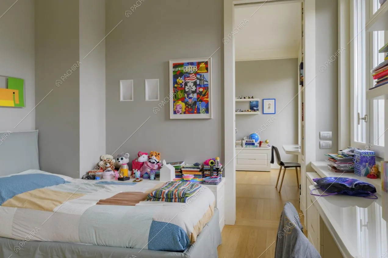 Camera da letto con scrivania bianca, pareti grigie e pavimento in parquet