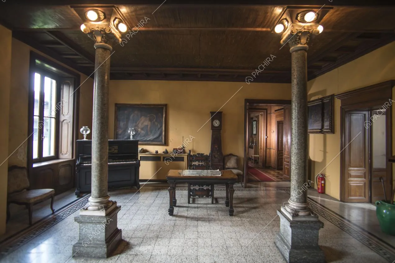 Spazio con colonne, scrivania, pianoforte a muro