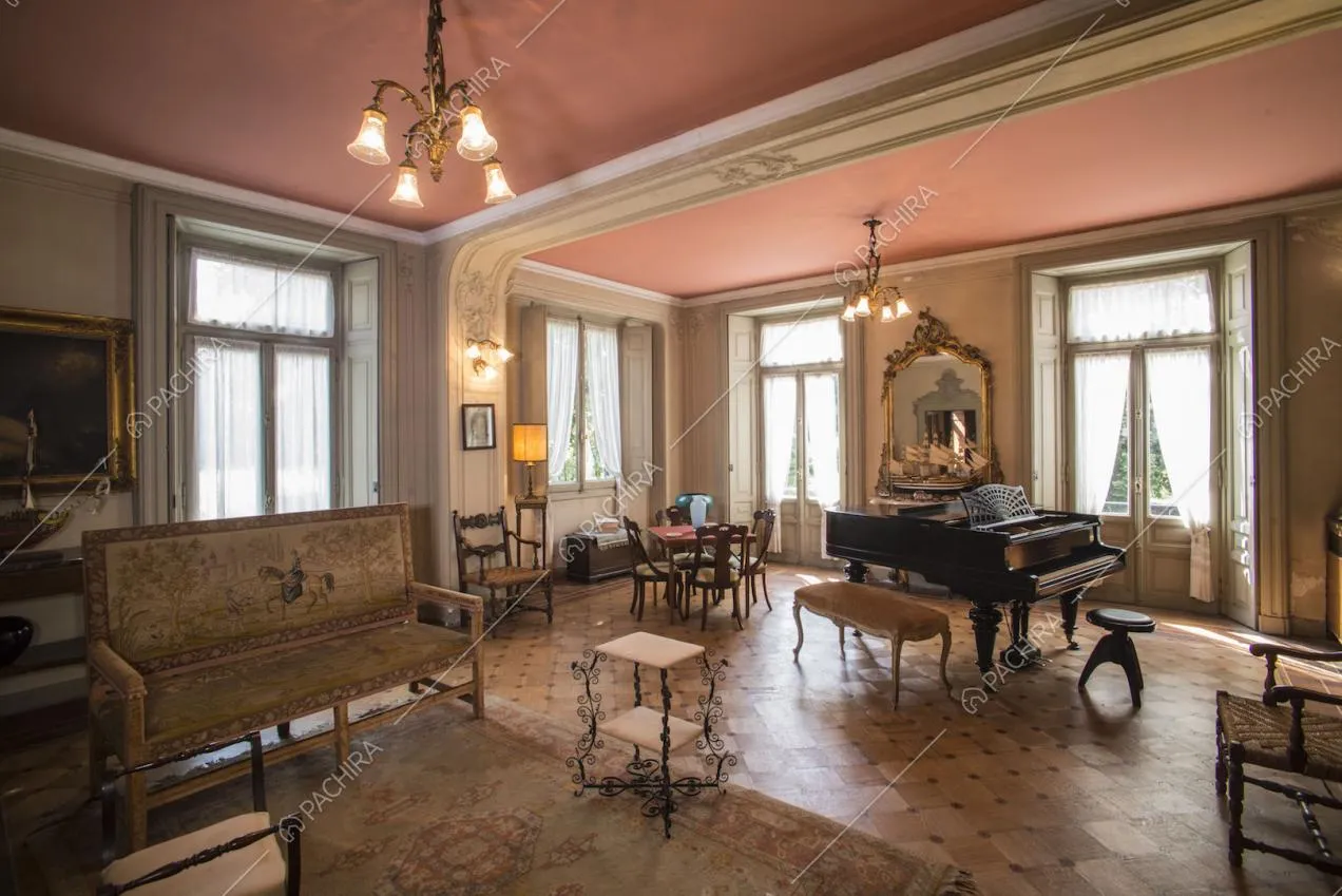 Zona living con divano d'epoca e pianoforte a mezza coda