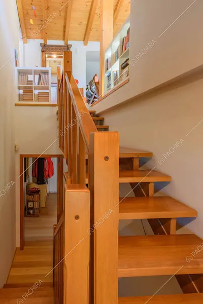 Pavimento in parquet, scale e travi a vista sul soffitto