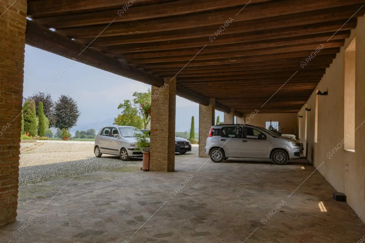 Tettoia con travi a vista in legno e colonne in mattoni