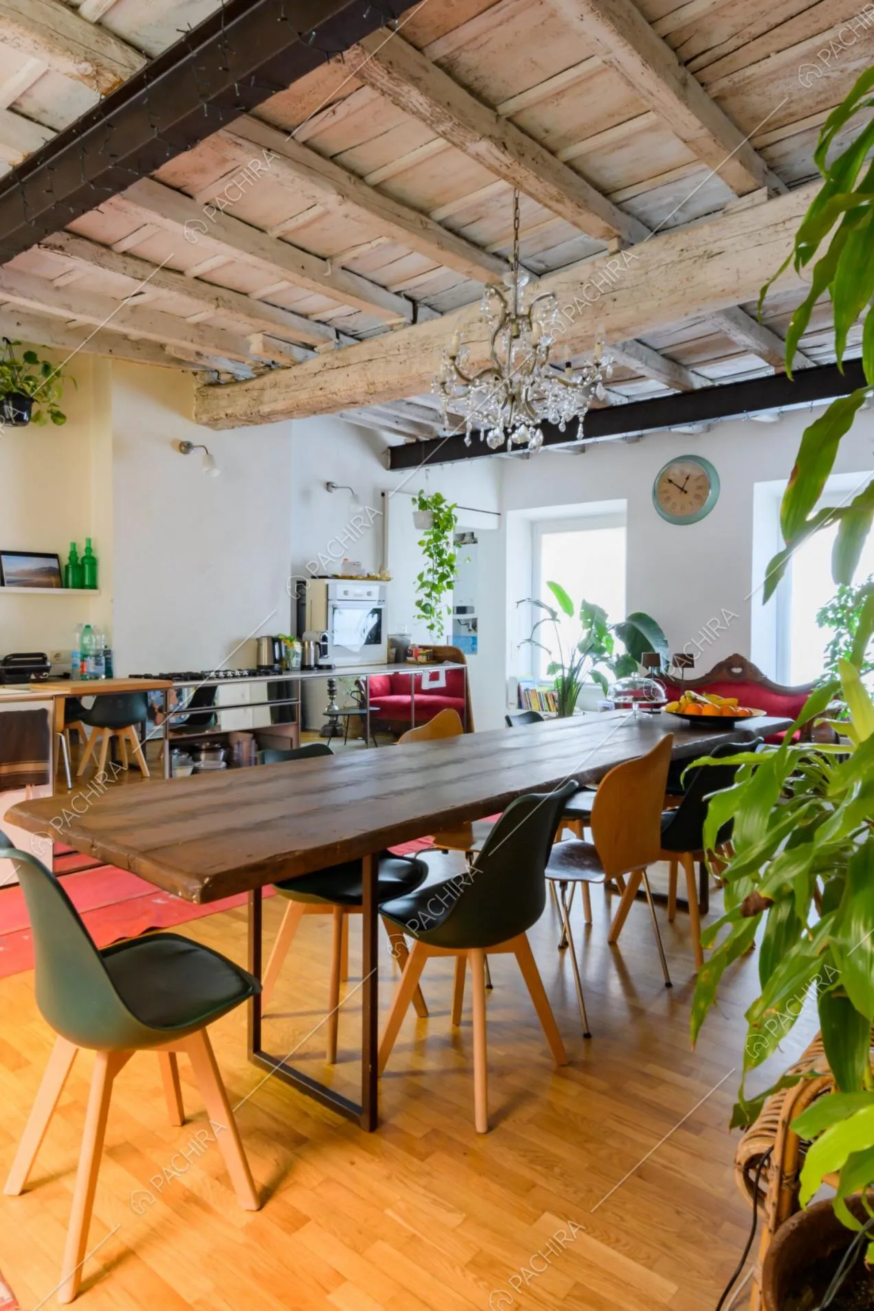 Grande cucina con tavolo da pranzo, pavimento in parquet e pareti bianche
