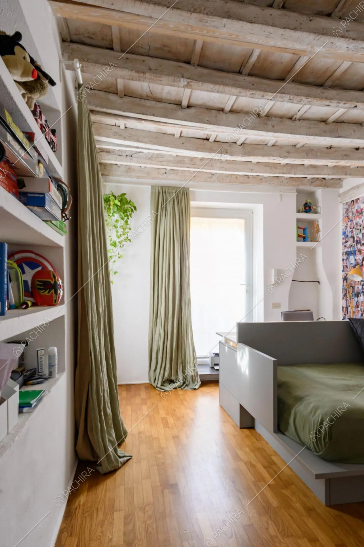 Camera da letto con tende verdi, pavimento in parquet e grande vetrata