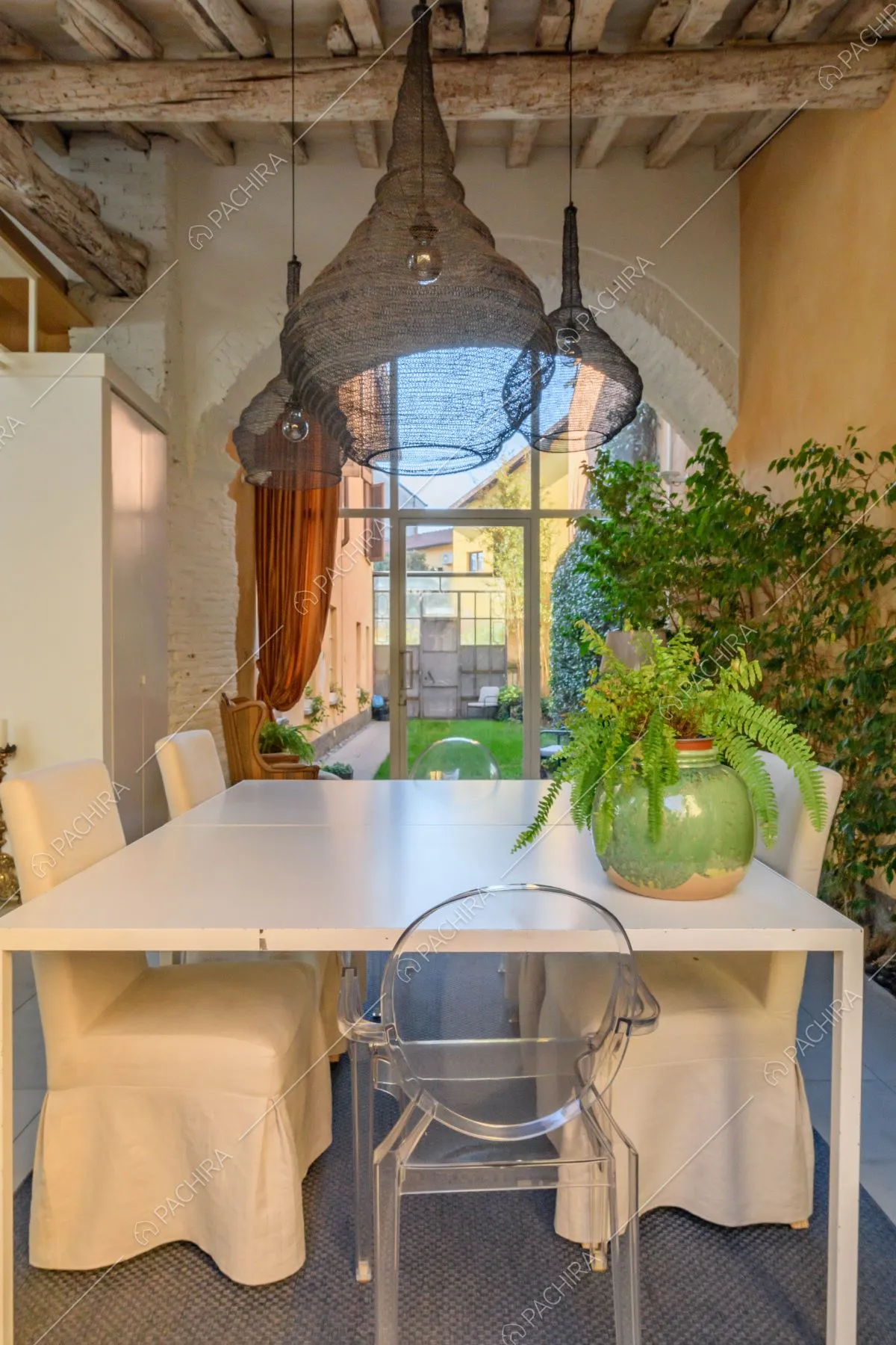 Nella luminosa veranda tavolo da pranzo e sedie bianche