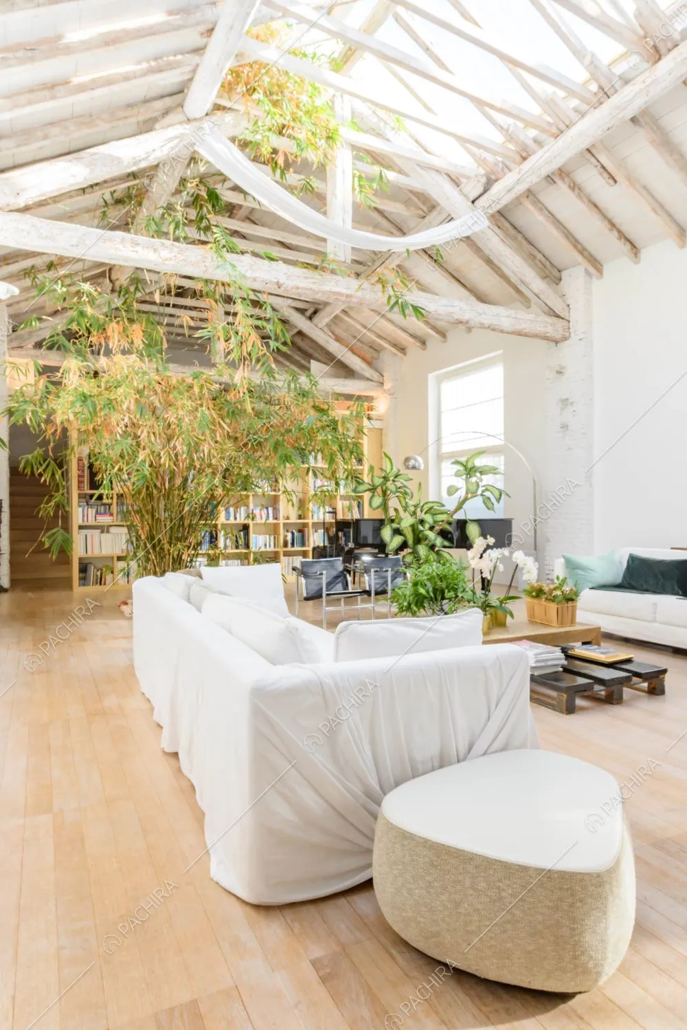 Pavimento in parquet nella luminosa sala con pareti bianche e travi a vista