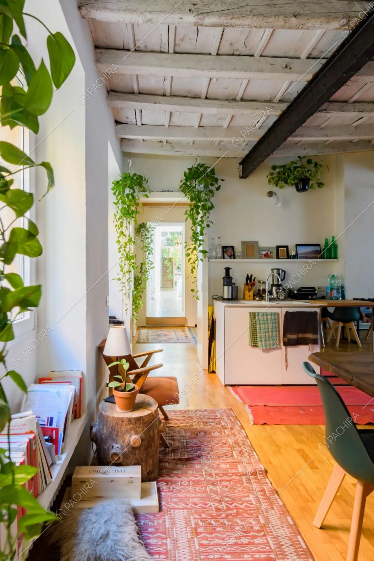 Luminosa cucina con pavimento in parquet, travi a vista e pareti bianche
