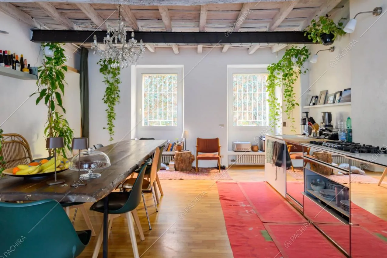 Cucina a parete con fornelli a gas e grande tavolo da pranzo in legno grezzo