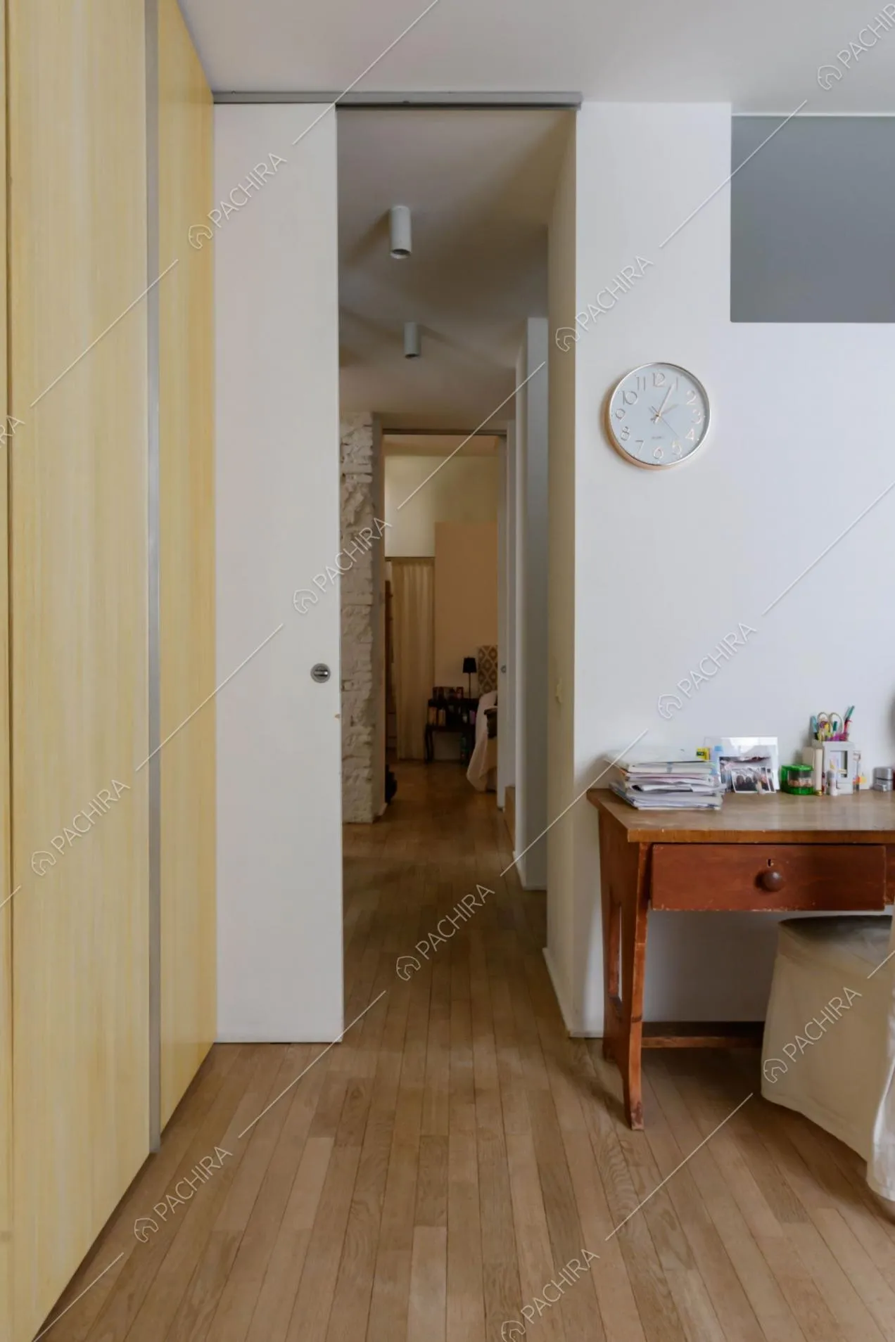 Dalla camera da letto con pareti bianche e pavimento in parquet vista sul corridoio
