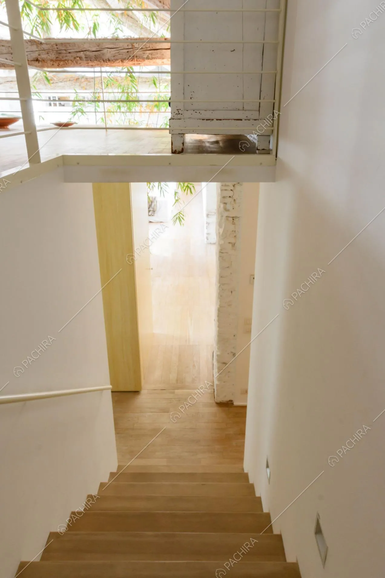 Scale in legno, pareti bianche e soppalco