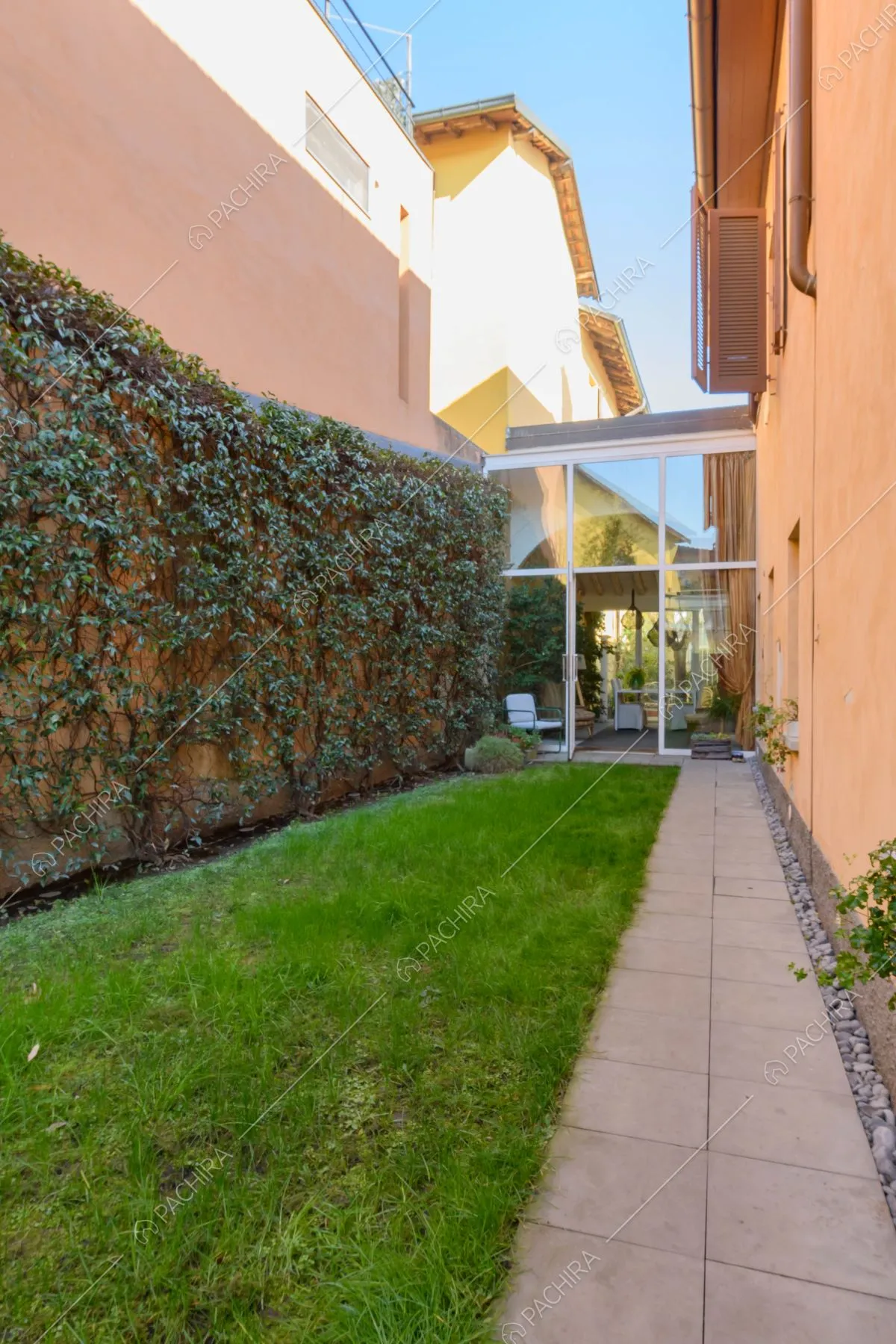 Giardino con vialetto e vista sulle vetrate della location