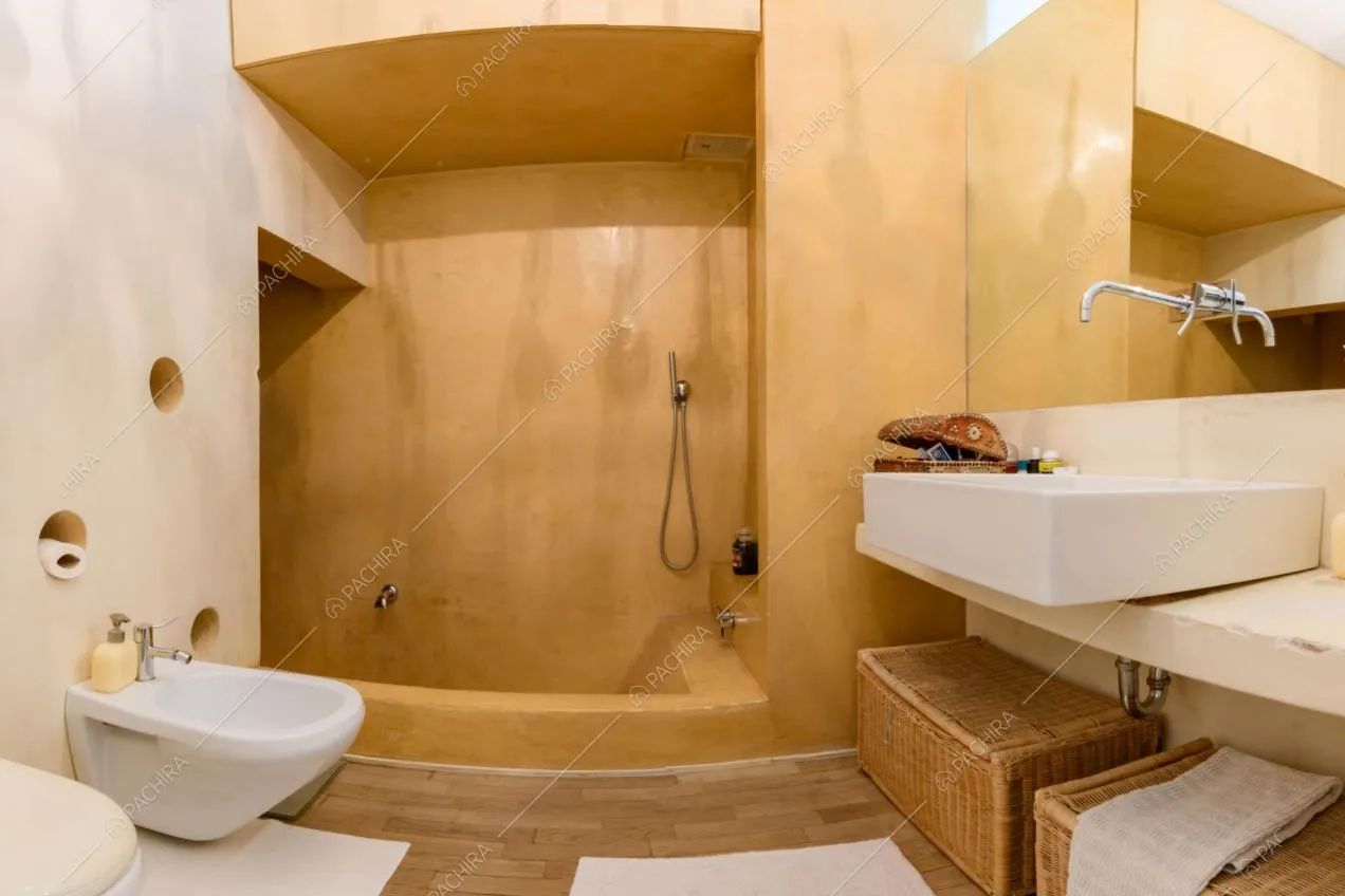 Bagno con vasca insieme a box doccia, pareti dorate e pavimento in parquet