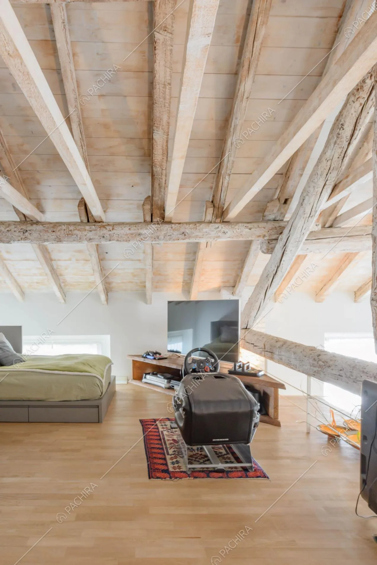 Soppalco con pavimento in parquet e ringhiera formata dallo stesso legno delle travi del soffitto
