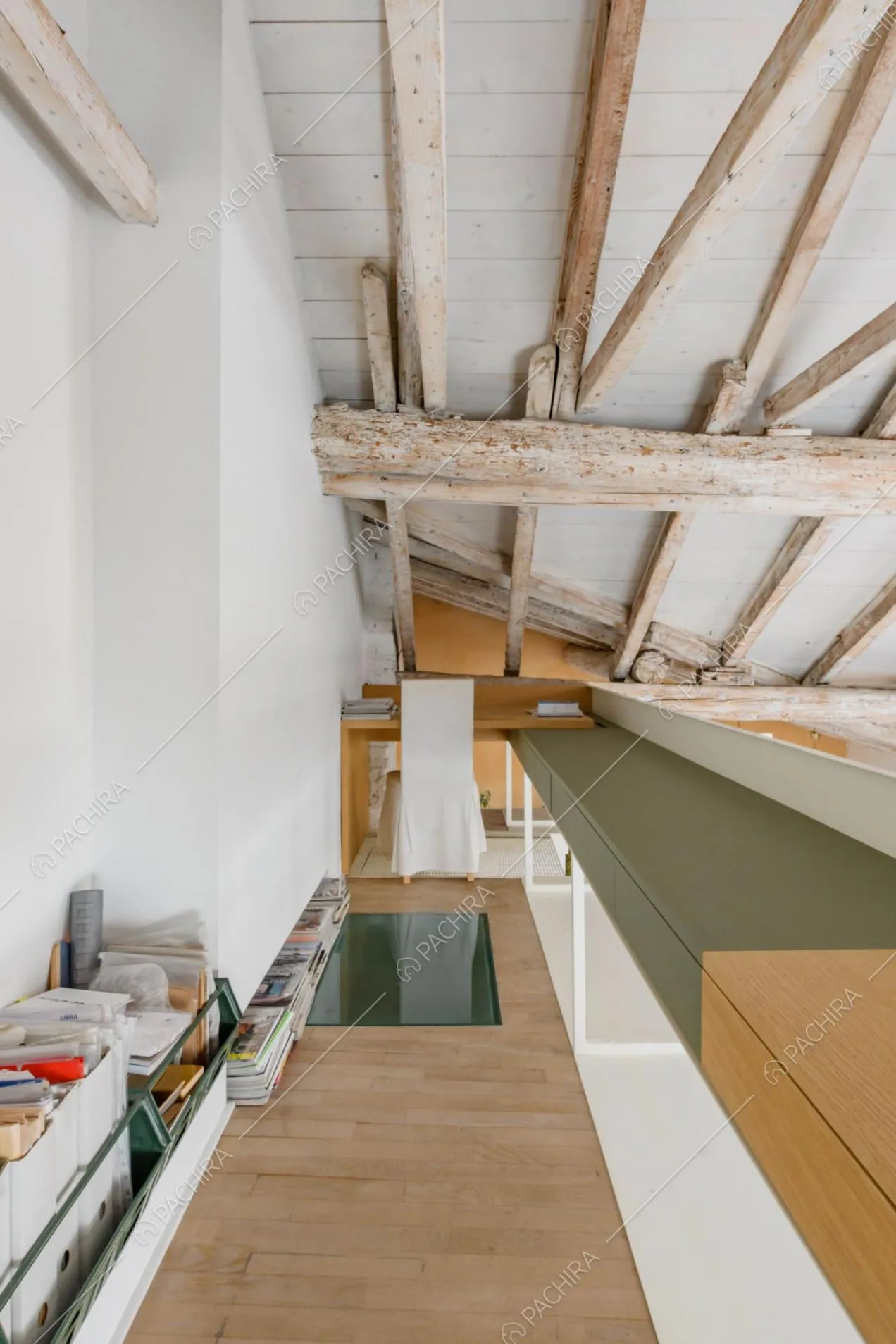 Sul soppalco studio con pavimento in parquet e scrivania arancione