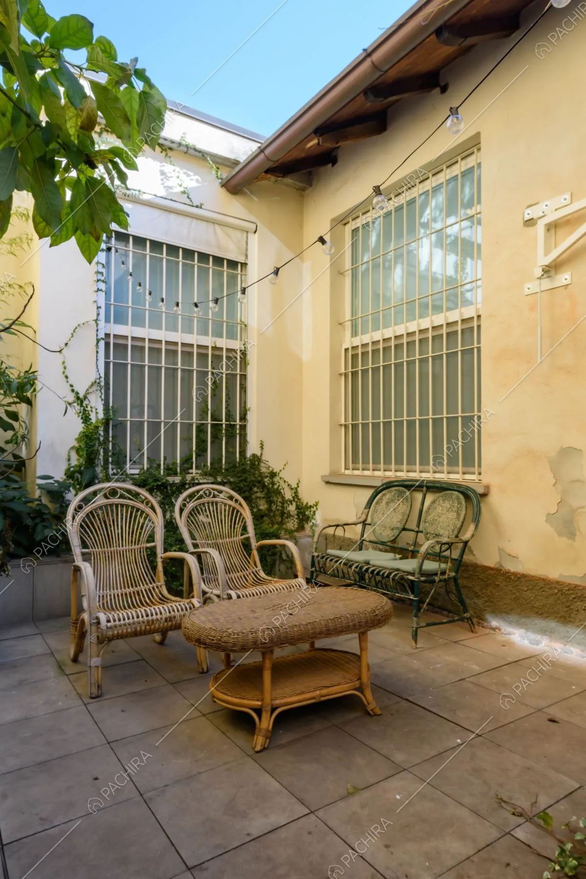 Sedie e tavolino in vimini nel cortile della location