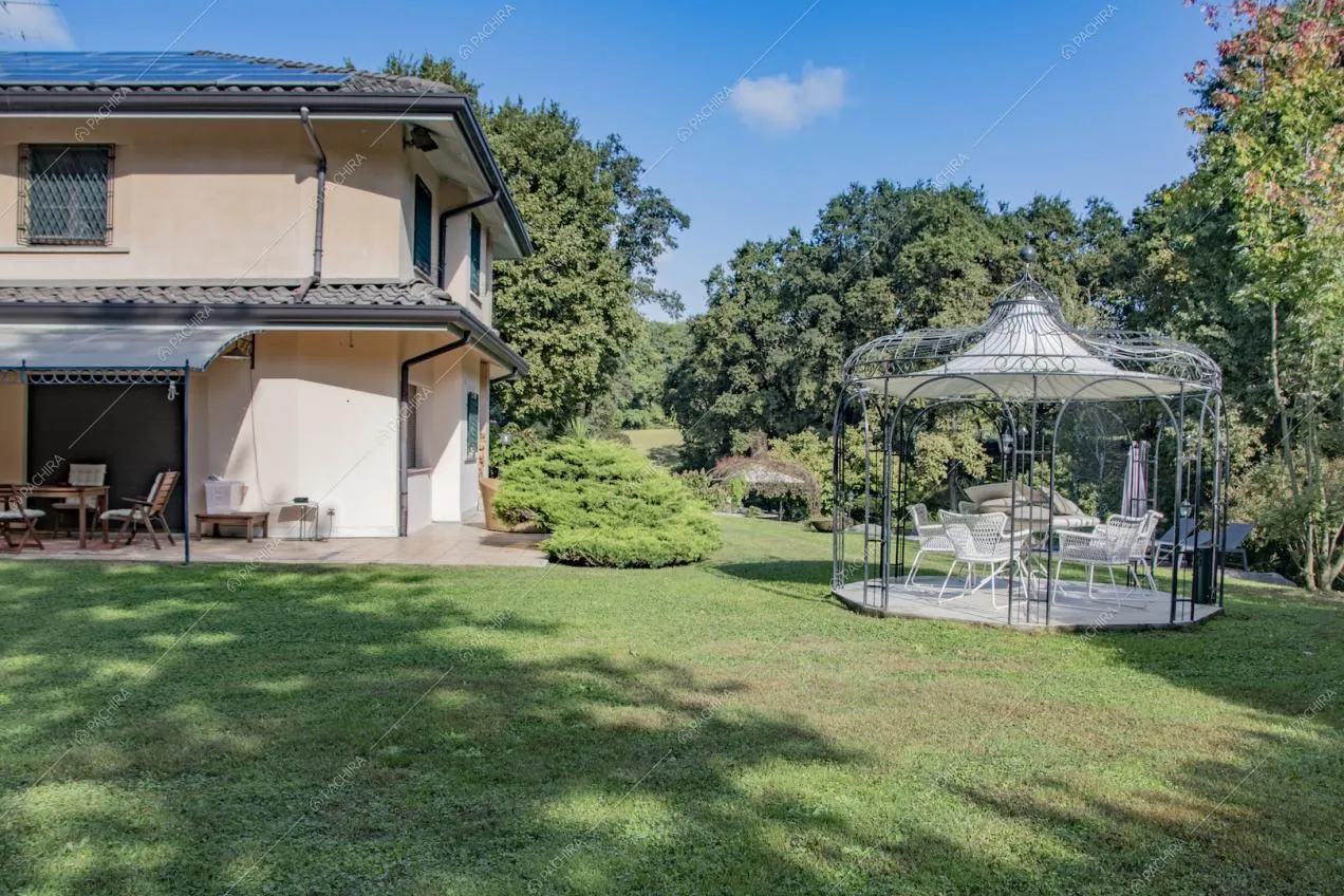 Curato giardino con gazebo e vista sugli esterni rosa della villa