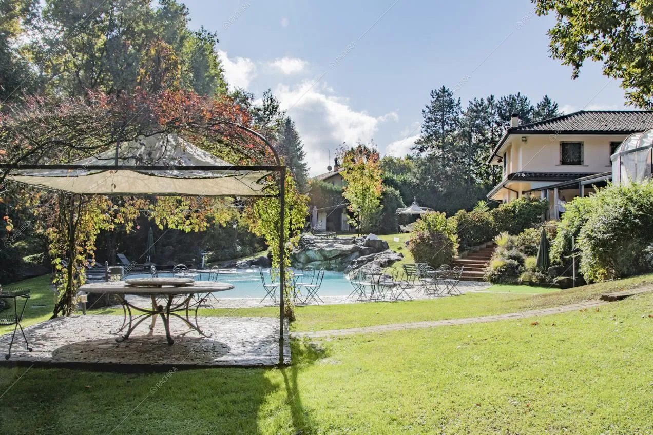 Elegante gazebo con rampicanti e scorcio sulla piscina