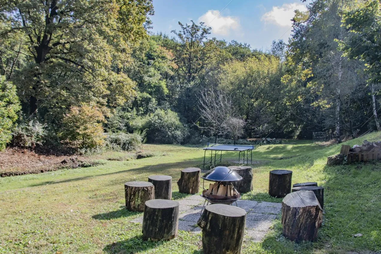 Giardino con sgabelli ricavati da tronchi e postazione per falò