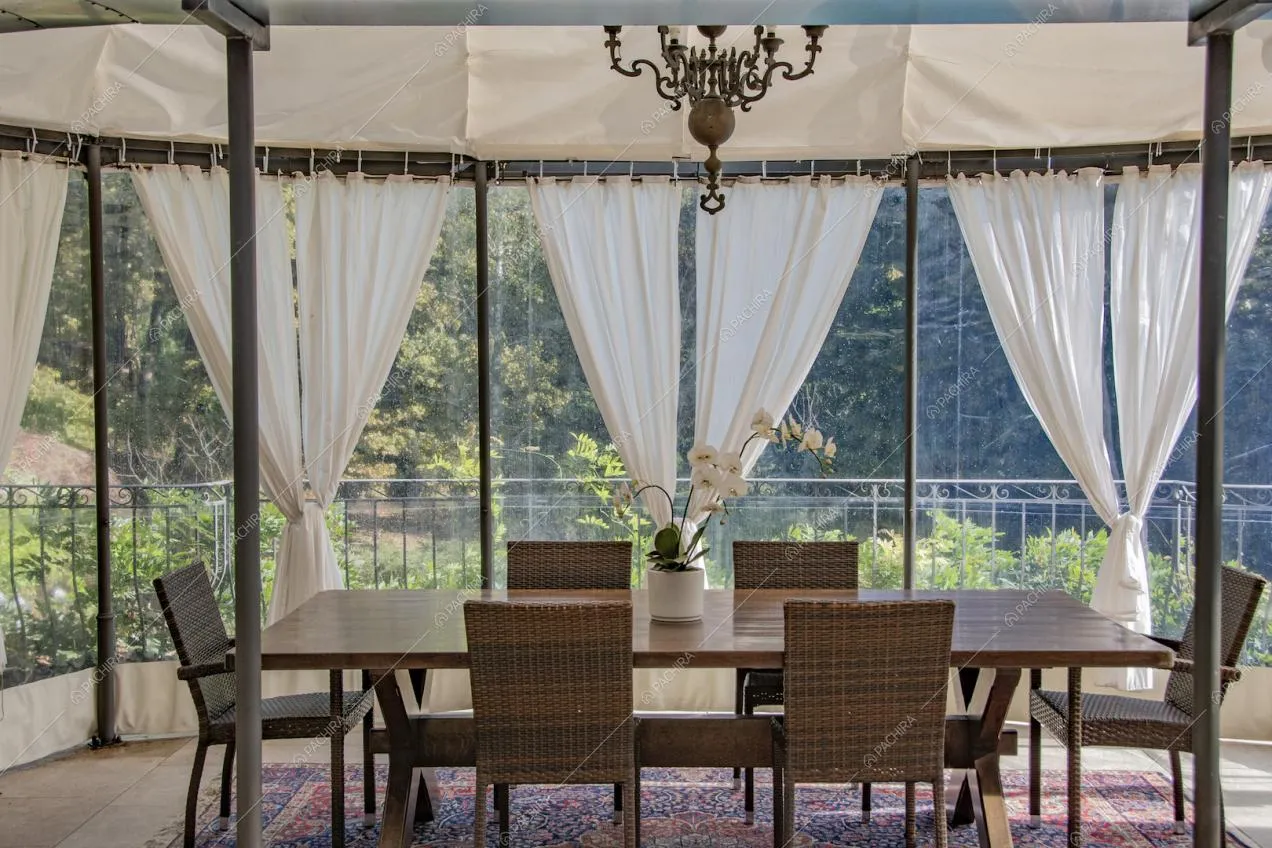 Tavolo da pranzo nella veranda con pareti e soffitto in vetro
