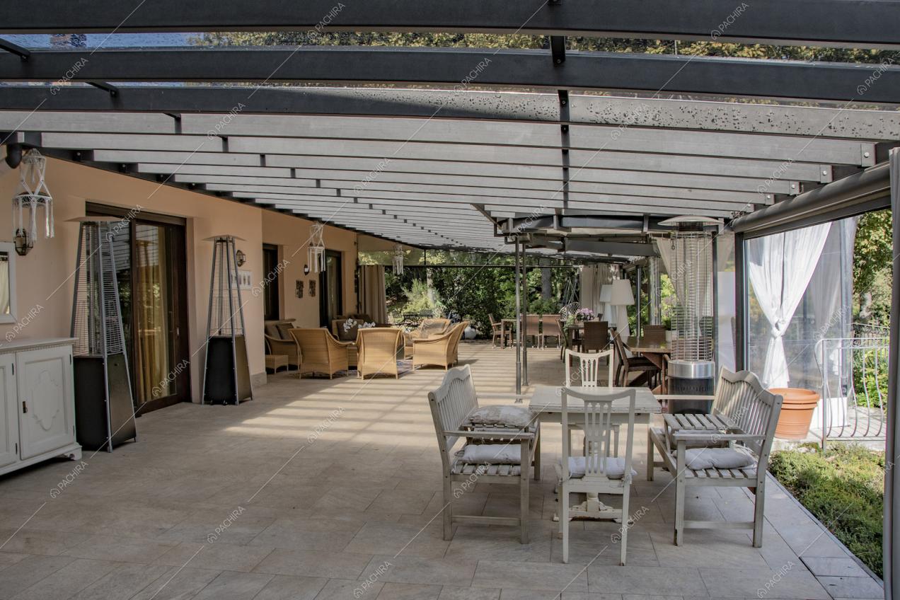 Pavimento in piastrelle e pareti rosate nella veranda con vista sul giardino