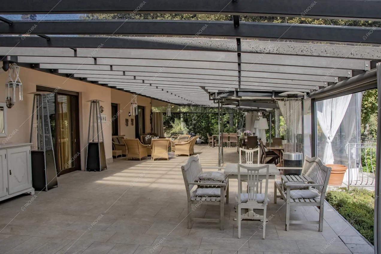 Pavimento in piastrelle e pareti rosate nella veranda con vista sul giardino