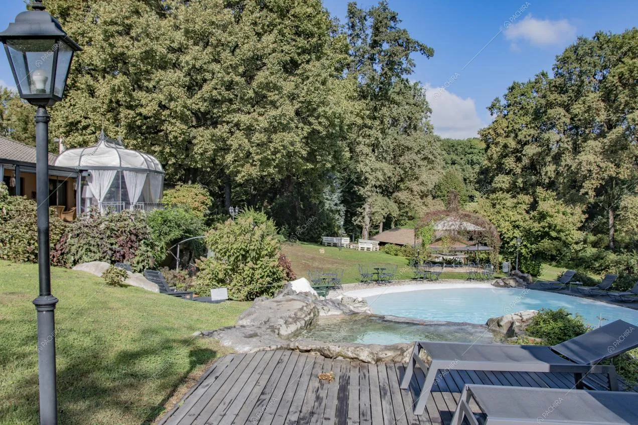 Lettini sul pavimento in legno della piscina e vista sul gazebo