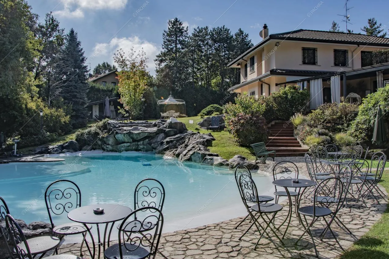 Nel giardino della villa ecco dei tavolini da esterni a bordo piscina