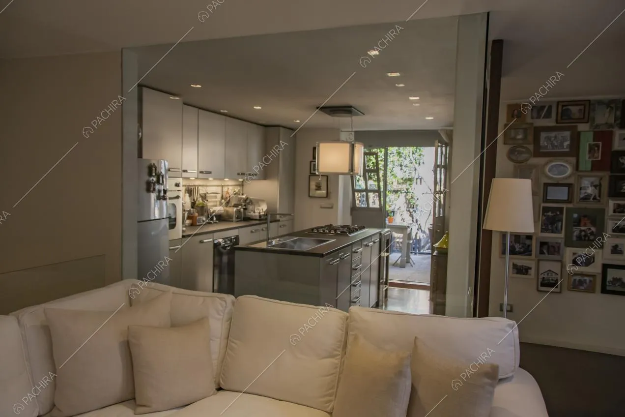 Cucina a isola bianca con faretti sul soffitto
