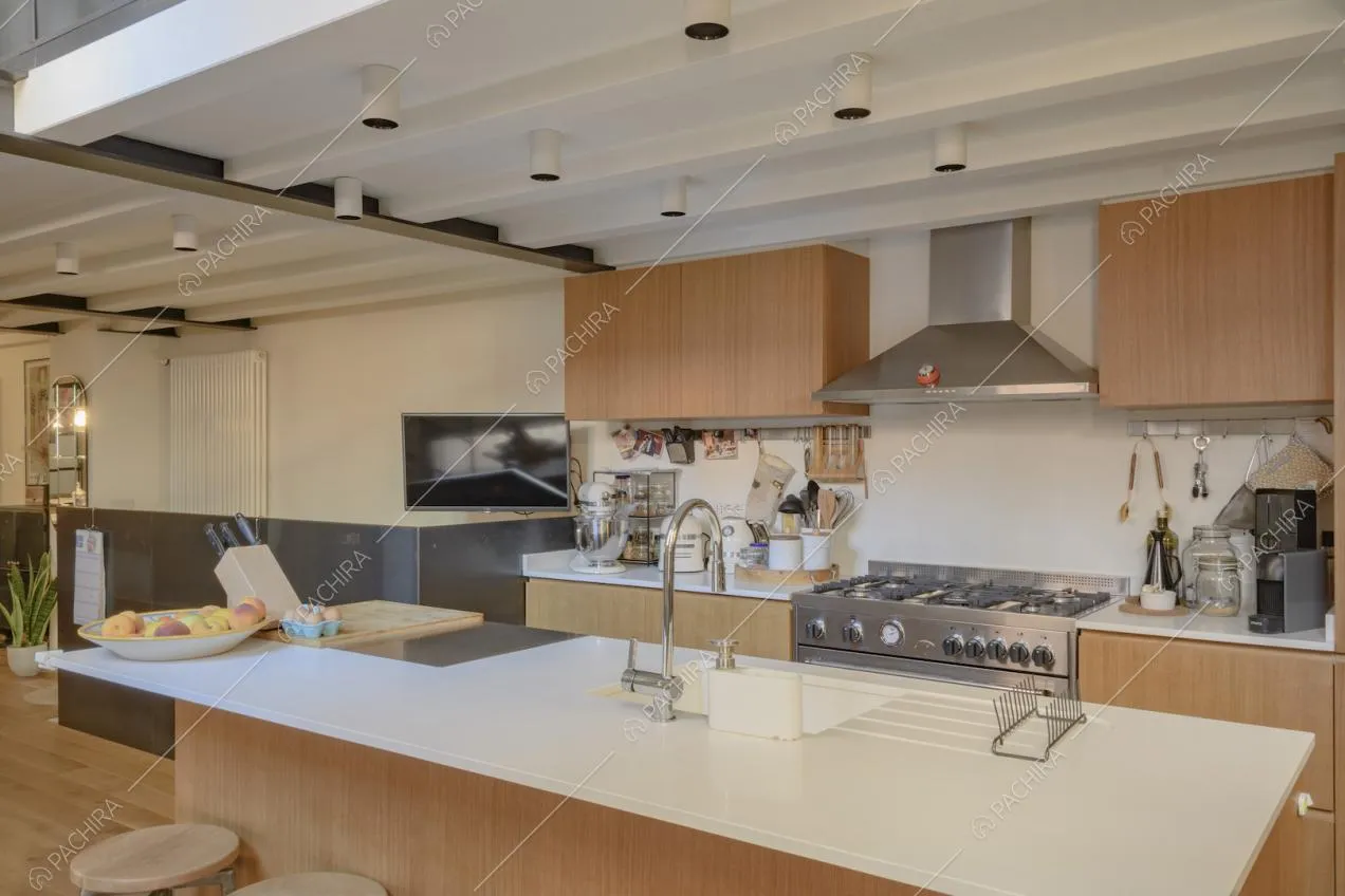 Ampia cucina a isola con mobili di colore chiaro