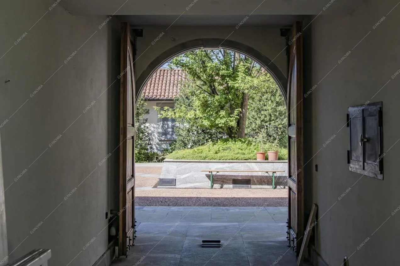 Vista sul cortile interno da un aargo con portone in legno