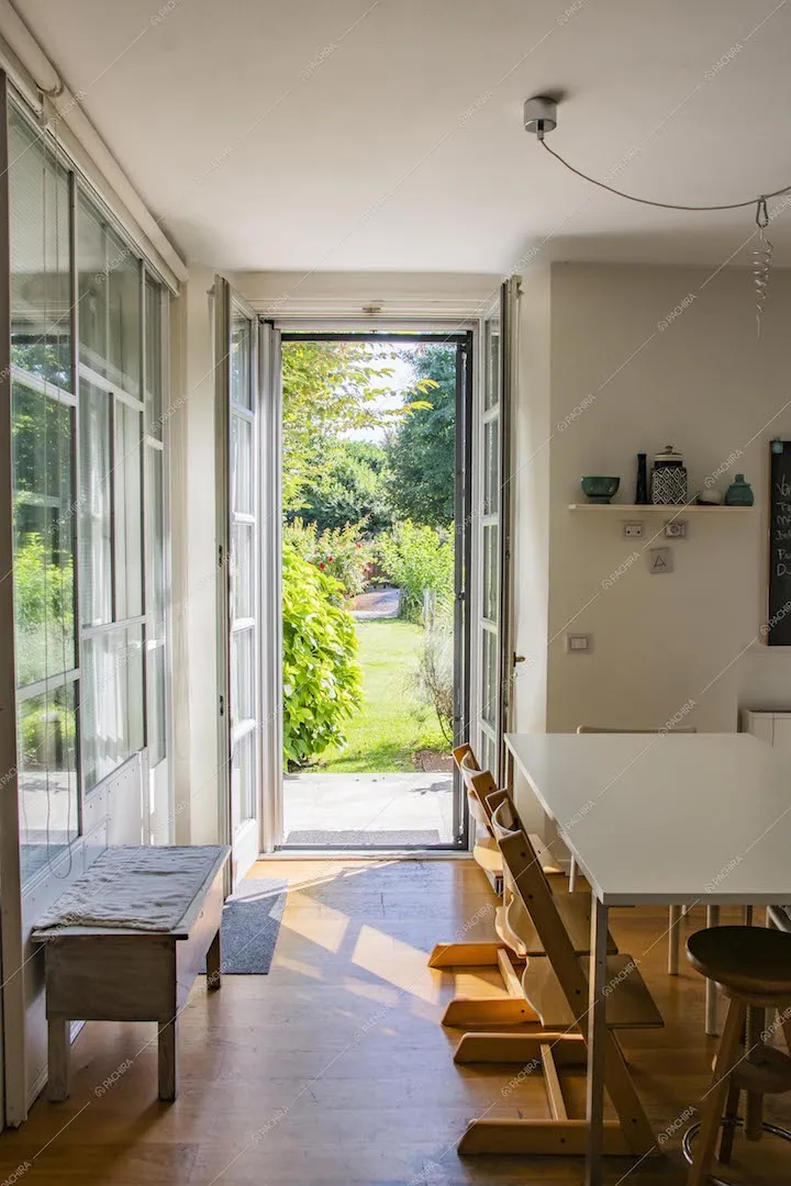 Dal salotto con pavimento in parquet e scorcio sul giardino dalla porta