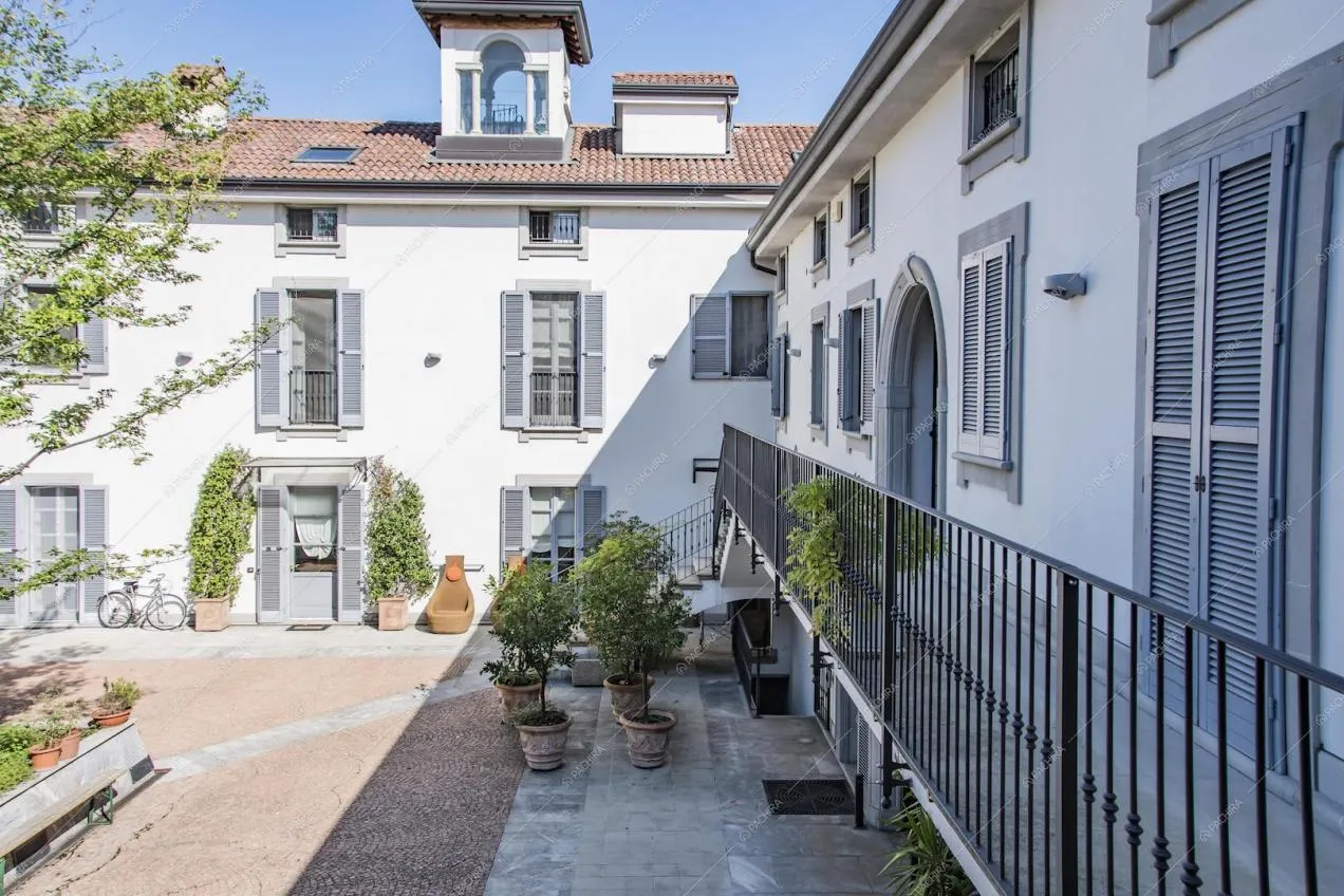 Esterni bianchi con pavimentazione in ciottoli e balcone