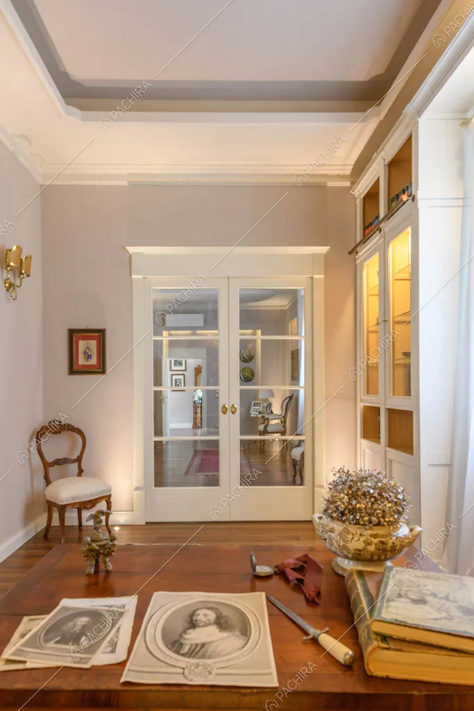 Dalla scrivania in legno vista sulla zona living tramite porta a vetri