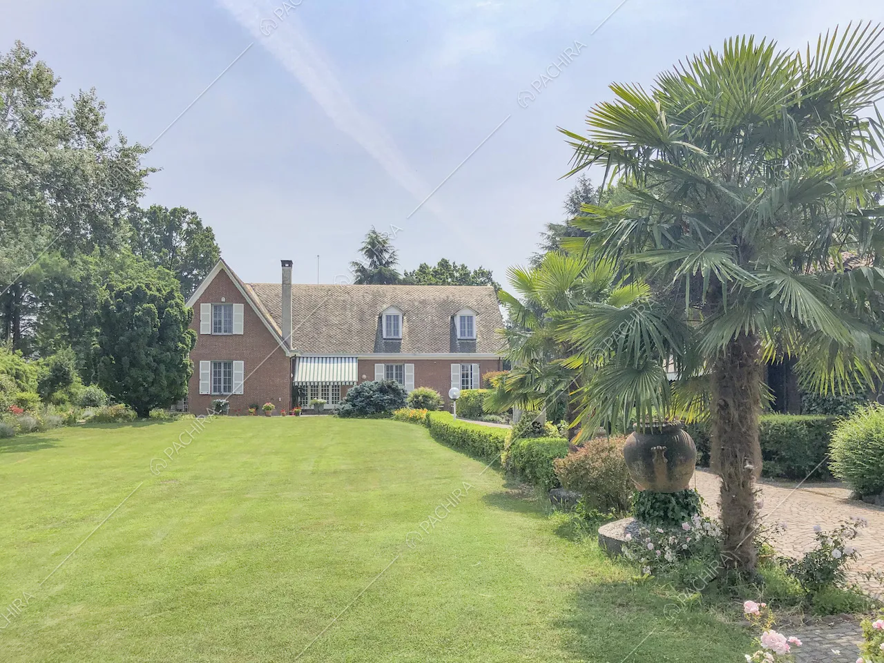 Prato davanti alla villa in stile inglese e palme