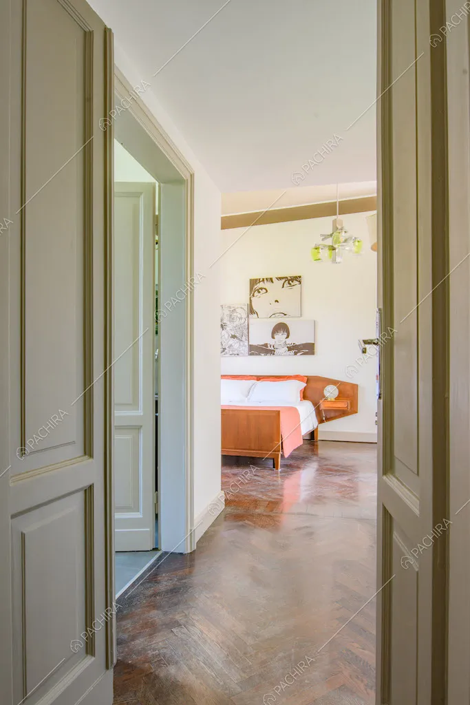 Pavimento in parquet a spina di pesce nella luminosa camera da letto matrimoniale