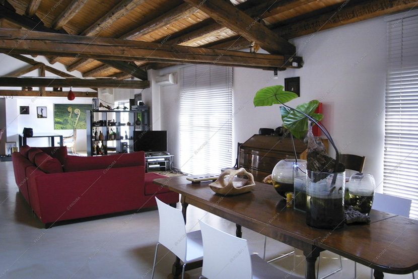 Zona living con tavolo in legno e divano rosso