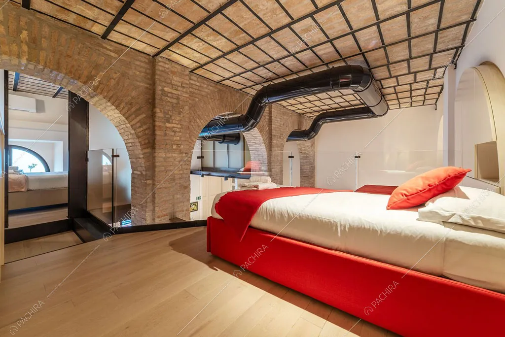 Camera da letto con parete in mattoni del loft Sabbia, location in stile moderno a Roma