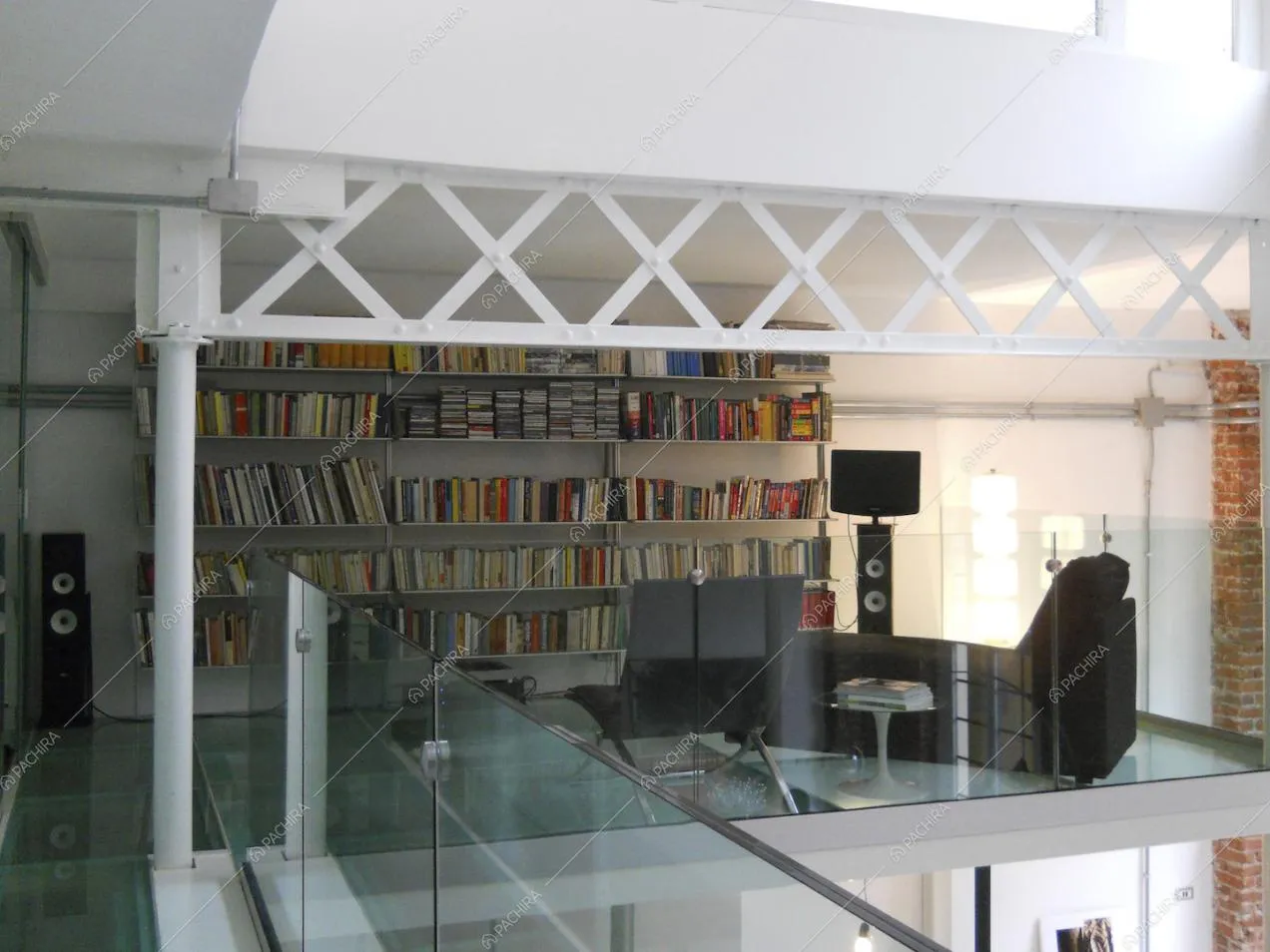 Sul soppalco biblioteca con balaustra e pavimento in vetro