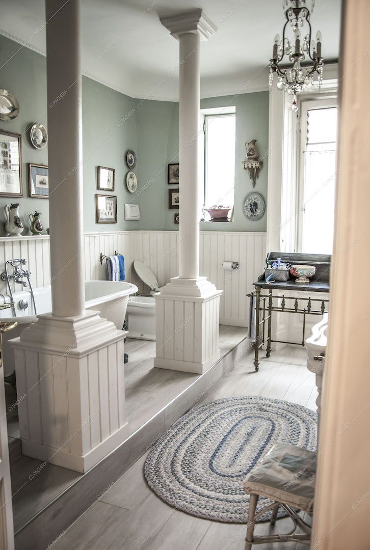 Bagno con vasca su piano rialzato e colonne bianche