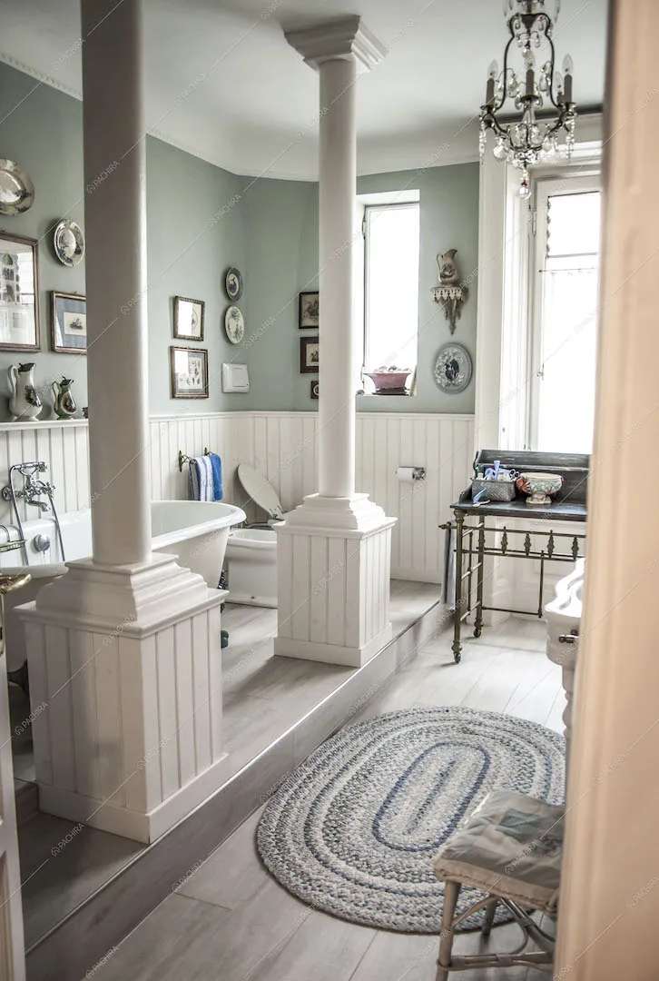 Bagno con vasca su piano rialzato e colonne bianche