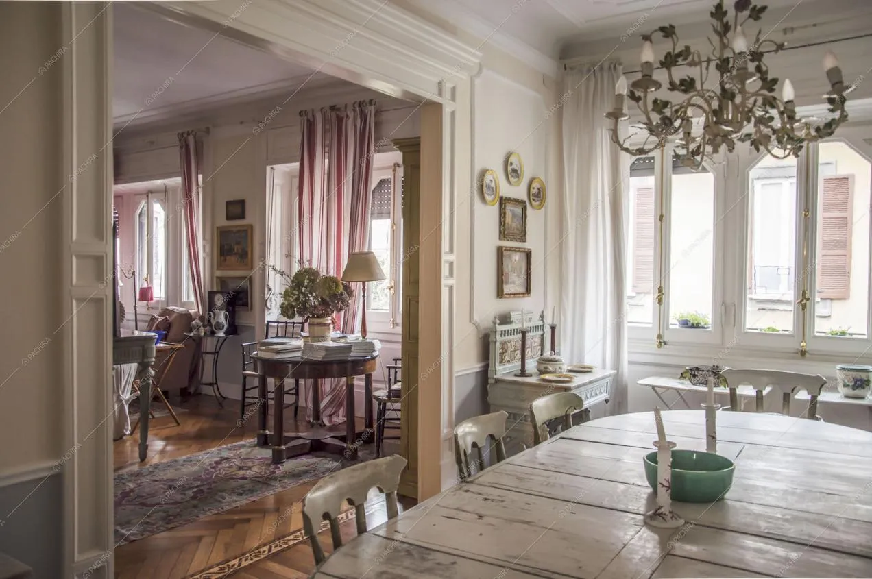 Pareti con boiserie, lampadario e tavolo da pranzo