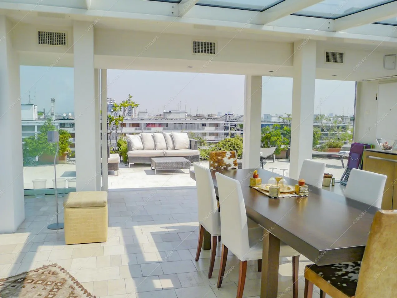 Tavolo da pranzo nella veranda e scorcio sul divanetto esterno